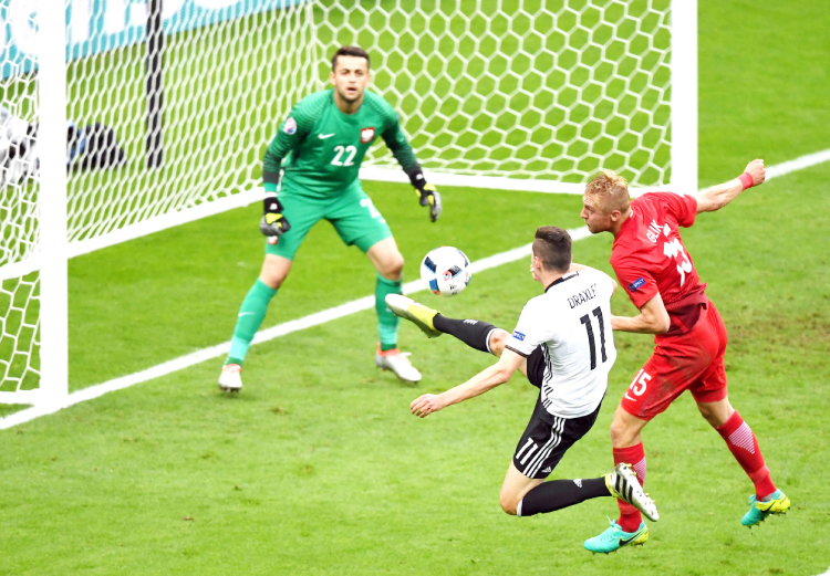 Germany’s midfielder Julian Draxler challenges the Polish goalkeeper during their Euro 2016 Group C match in Saint Denis near Paris Thursday. — AFP