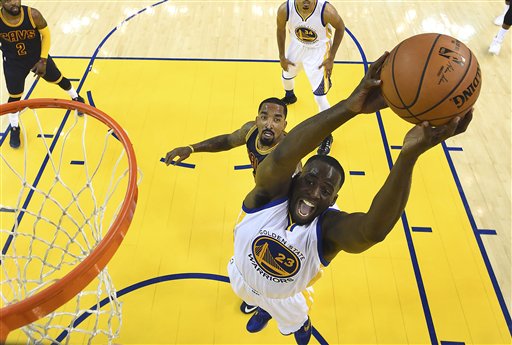 Golden State Warriors forward Draymond Green shoots in front of Cleveland Cavaliers guard J.R. Smith. AP