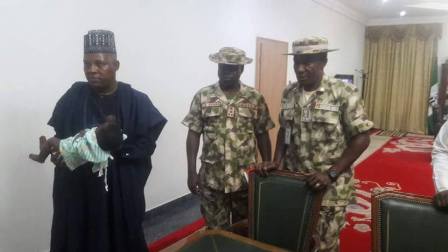 Governor Shettima holding the girl's baby