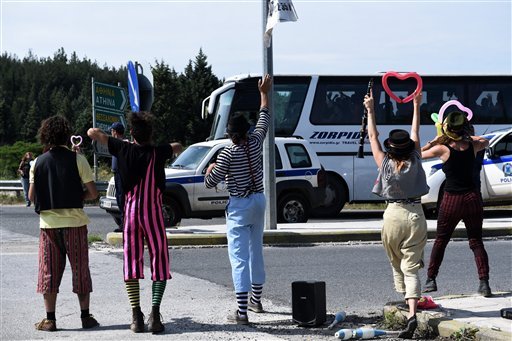 Activists wave to a bus transferring migrants to an organized camp during an operation to evacuate the makeshift refugee camp at the Greek Macedonian border near the northern Greek village of Idomeni Tuesday