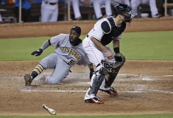 J.T. Realmuto right waits for the throw while Pittsburgh Pirates Josh Harrison slides into home plate as he and Francisco Cervelli scored on a single by Matt Joyce during the seventh inning of a baseball game Wednesday Jun