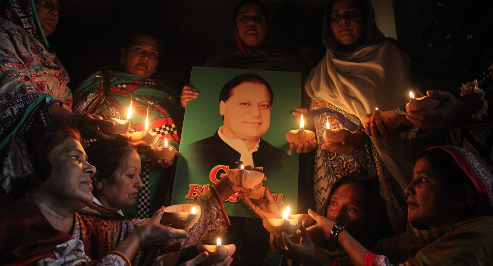 Supporters of Pakistan's Prime Minister Nawaz Sharif hold oil lamps as they pray for his early recovery