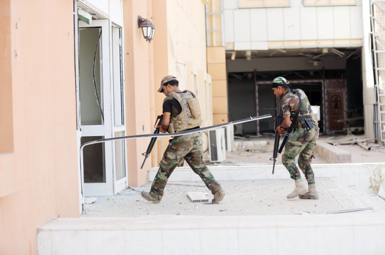 Iraqi soldiers enter the main hospital in Falluja Iraq. — AP