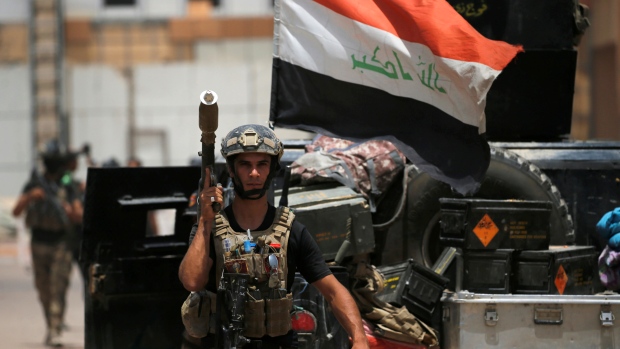 A member of the Iraqi security forces carries his weapon at Fallujah hospital in centre of Fallujah Iraq on Monday. Iraq's armed forces have dislodged ISIS militants from two eastern districts and are pushing them back into a handful of northern and