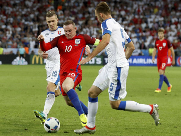 England's Wayne Rooney center is challenged by Slovakia's Juraj Kucka left and Norbert Gyomber during the Euro 2016 Group B soccer match between Slovakia and England