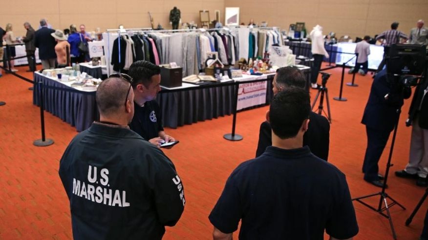 U.S. Marshals keep watch on a room full of personal items belonging to James'Whitey Bulger and Catherine Greig ahead of a court-ordered auction in Boston