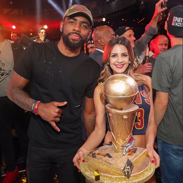 Celebration! Kyrie Irving poses with the trophy and a woman in Las Vegas- shortly before she was doused in champagne poured by a shirtless JR Smith as the festivities escalated in Sin City on Sunday night