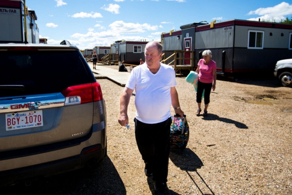 John E. Smith begins loading bags into his vehicle as he and other evacuees prepare to leave Wandering River Alta