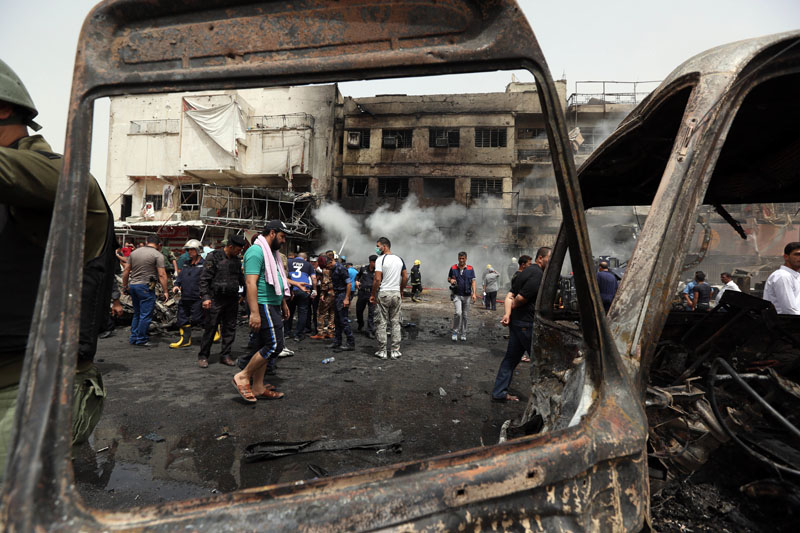 Iraqi security forces and civilians gather at the scene of a deadly suicide car bomb attack in the New Baghdad neighborhood of Baghdad Iraq Thursday