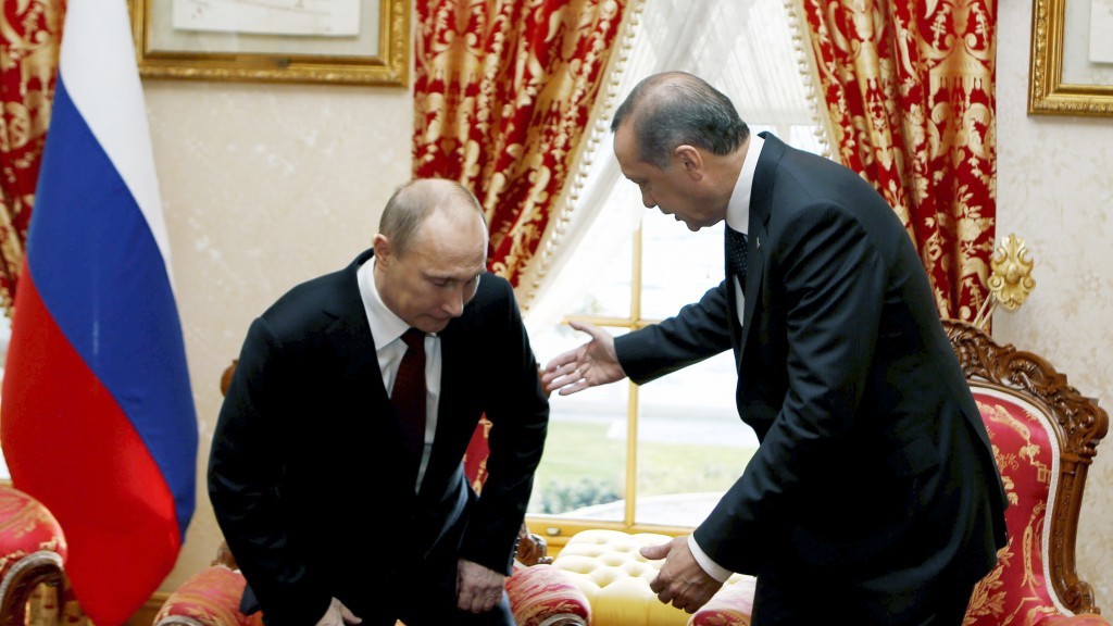 Russian President Vladimir Putin sits down as Turkey's Prime Minister Recep Tayyip Erdogan looks on before a meeting in Istanbul Turkey