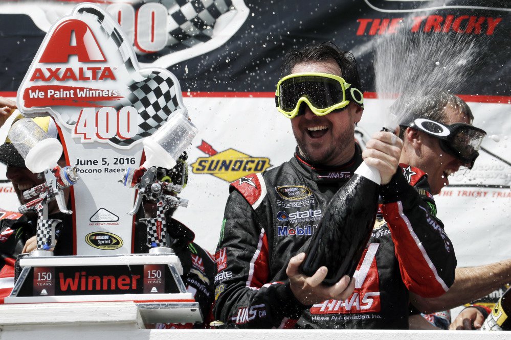 Kurt Busch celebrates with his team in victory lane after winning the NASCAR Sprint Cup race Monday at Pocono Raceway in Long Pond Pennsylvania