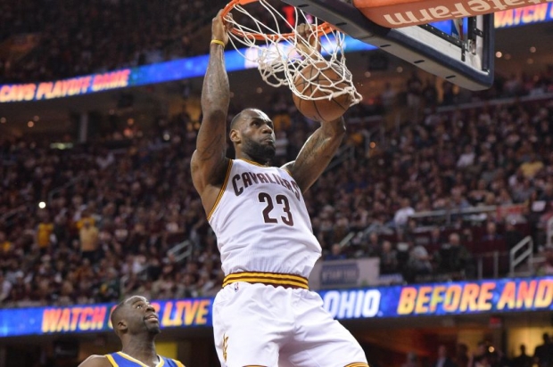 Cleveland Cavaliers forward Le Bron James dunks the ball in front of Golden State Warriors forward Draymond Green during the four quarter in game three of the NBA Finals at Quicken Loans Arena. — Reuters pic