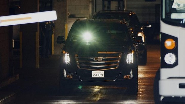 Quick getaway... A man shines a flashlight to block the view of cameras as two SUVs believed to be transporting Jimmy Page and Robert Plant two of Led Zeppelin's founder members depart federal court in Los Angeles