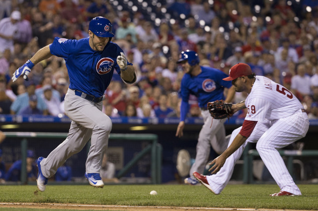 Chicago Cubs Matt Szczur left hit a sacrifice bunt as Kris Bryant center comes in to score as Philadelphia Phillies relief pitcher Elvis Araujo, right