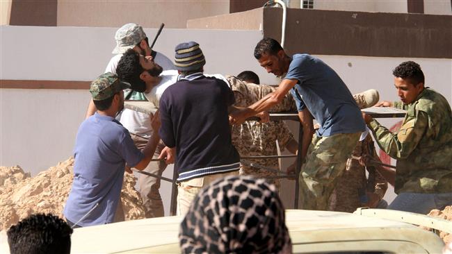 Forces loyal to Libya's UN-backed unity government carry a comrade wounded during clashes with terrorists in the city of Sirte 450 kilometers east of Tripoli as they take part in an operation to recapture the city from Daesh on June 12