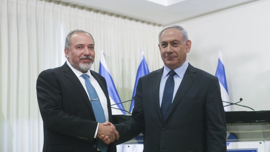 Prime Minister Benjamin Netanyahu and Yisrael Beytenu party leader Avigdor Liberman shake hands after signing a coalition agreement in the Knesset on Wednesday