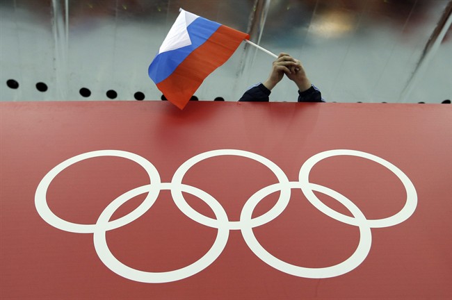 Russian skating fan holds the country's national flag over the Olympic rings before the start of the men's 10,000-meter speedskating race at Adler Arena Skating Center during the 2014 Winter Olympics in Sochi