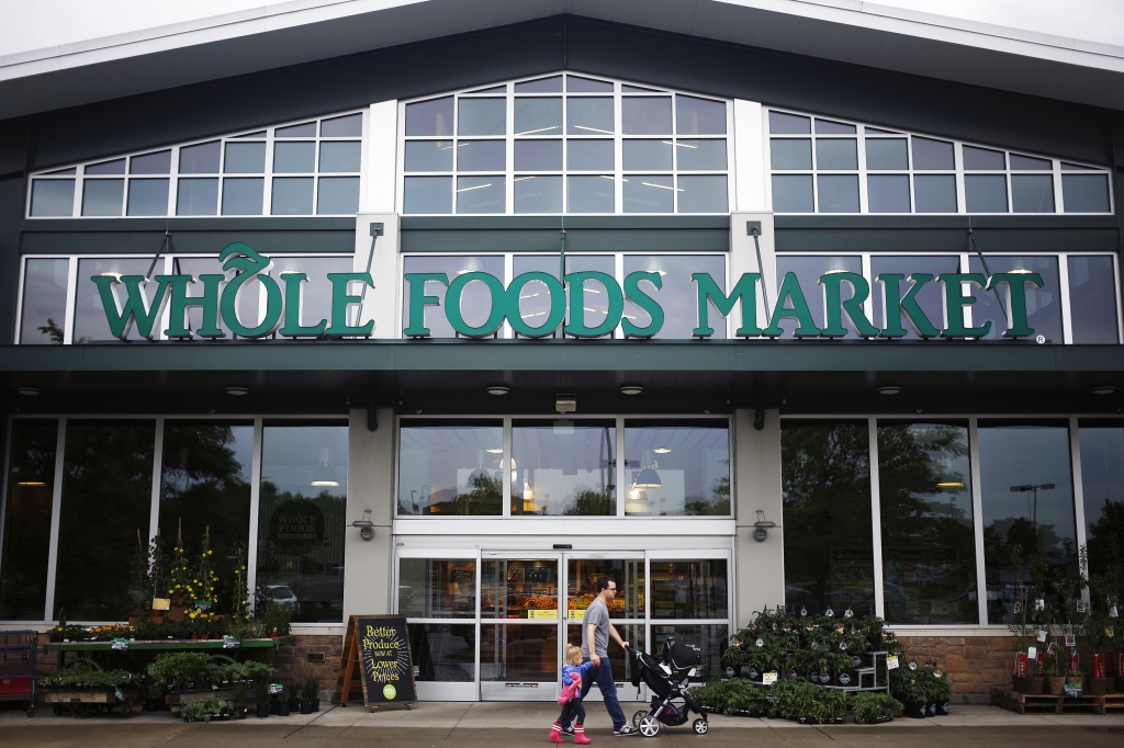 A shopper walks in front of a Whole Foods store in Franklin