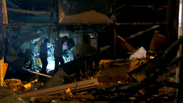 Policemen inspect the damage at the site of an explosion at the headquarters of the Lebanese Blom Bank in Beirut Lebanon