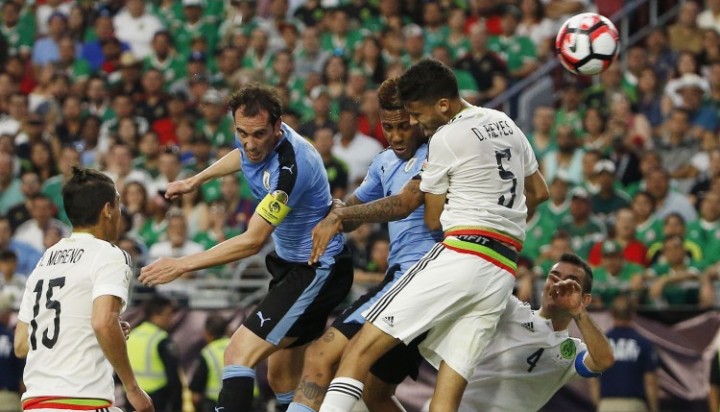 Uruguay's Diego Godin second from left heads the ball to the goal for a score sending it past Mexico's Diego Reyes, Rafael Marquez and teammate Abel Hernandez as Mexico's Hector Moreno looks on during the second half of a Co