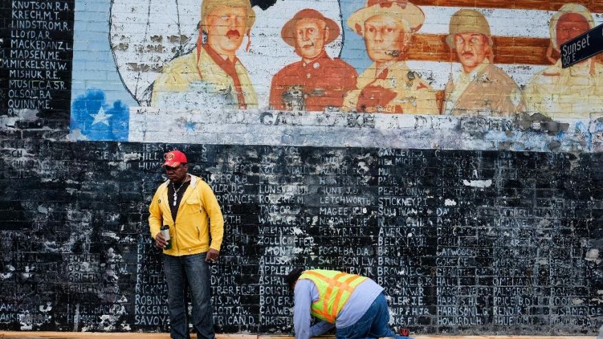 Former U.S. Marine Jon Scudder left watches as a Metropolitan Transit Authority worker prepares to cover a vandalized Vietnam War Memorial in the Venice area of Los Angeles on Monday