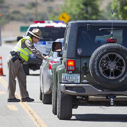 Public Safety Sgt. Angelo Trujillo directs a driver to turn around at a roadblock on Highway 89 at Hayes Ranch Road in Peeples Valley Ariz. Thursday