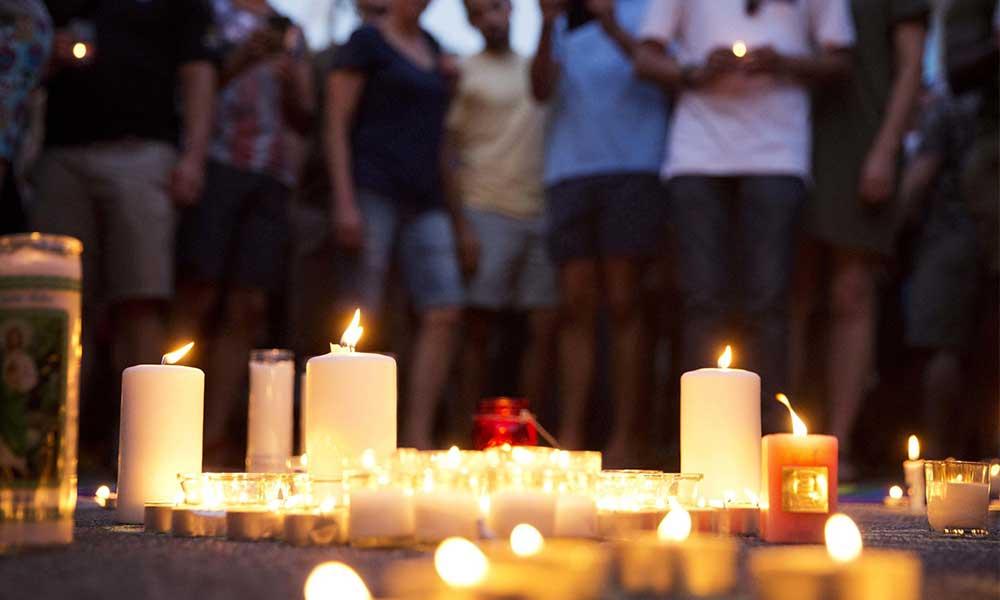 Mourners gather around candles lit during a vigil after the deadly shooting at the Pulse Orlando nightclub on Sunday