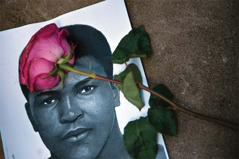 A flower and an image of Muhammad Ali are seen as people leave items to pay their respects to boxing legend Muhammad Ali at the Muhammad Ali Center in Louisville Kentucky. — AFP