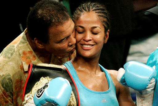 WBC and WIBA super middleweight champion Laila Ali is kissed by her father boxing great Muhammad Ali at the MCI Center in Washington