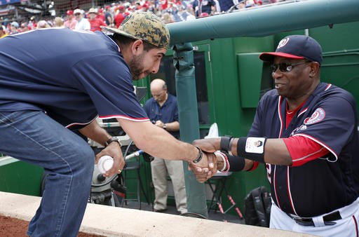 Medal of Honor recipient retired U.S. Army Capt. Florent'Flo Groberg left is greeted by Washington Nationals manager Dusty Baker before a baseball game between the Nationals and the St. Louis Cardinals at Nationals Park Su