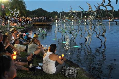 People hold candles at a candlelight vigil for the victims of the mass shooting at Pulse nightclub in Orlando as they gather at Lake Eola Park in Orlando Fla. Sunday