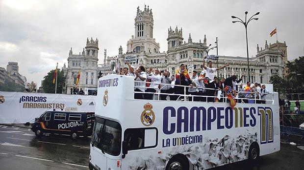 Real Madrid players and officials on board a team bus during a parade in the Spanish capital yesterday