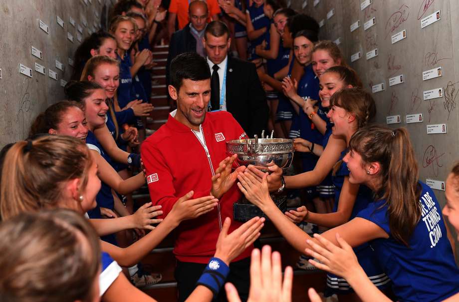 Novak Djokovic celebrates his French Open championship with the ball girls at Roland Garros