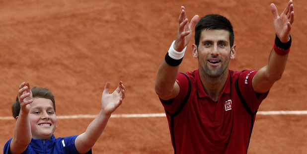 Novak Djokovic right teaches a ballboy how to celebrate a victory