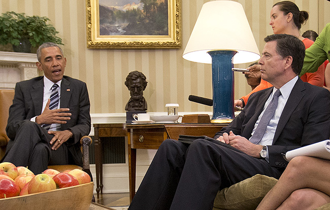 FBI Director James Comey right listens to President Barack Obama left speak to members of the media in the Oval Office of the White House in Washington Monday