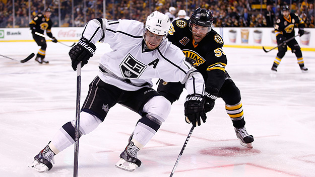 Anze Kopitar of the Los Angeles Kings carries the puck in the offensive zone in front of Johnny Boychuk of the Boston Bruins