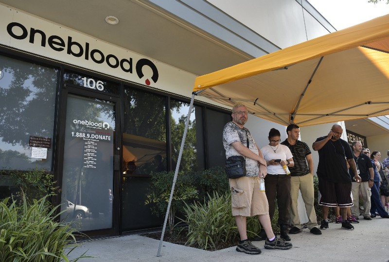 People wait to donate blood at the One Blood center