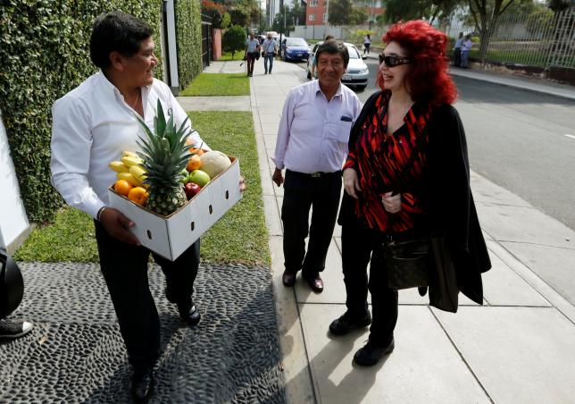 A neighbour gives a box of fruit as a present for Peruvian presidential candidate Pedro Pablo Kuczynski to an employee in Lima Peru