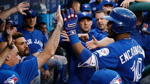 Toronto Blue Jays&#39 Edwin Encarnacion celebrates with teammates in the dugout after hitting a home run off Philadelphia Phillies starting pitcher Jeremy Hellickson during the second inning of Wednesday's game