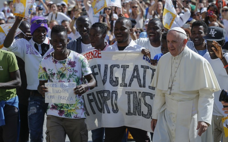 Pope Francis walks with a group of refugees this morning