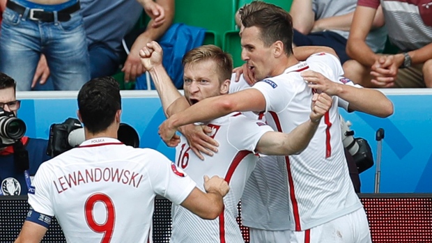 Poland's Jakub Blaszczykowski center celebrates with teammates after scoring during the Euro 2016 round of 16 soccer match between Switzerland and Poland at the Geoffroy Guichard stadium in Saint-Etienne France Saturday