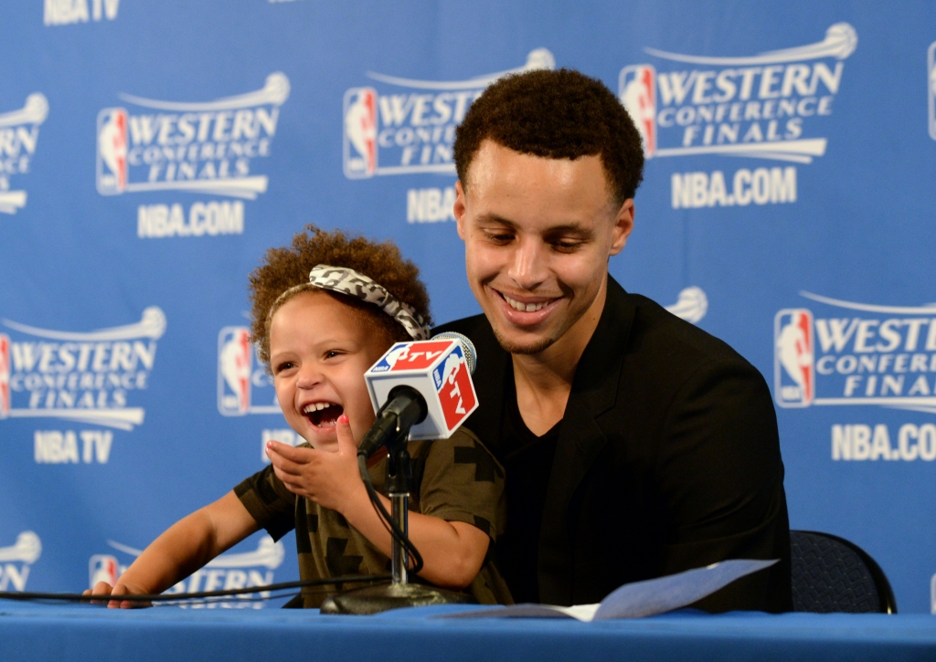 OAKLAND CA- MAY 19 Stephen Curry #30 of the Golden State Warriors and his daughter Riley talking with the media at a press conference after the game against the Houston Rockets during Game One of the Western Conference Finals during the NBA Playoffs