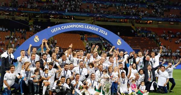 Milan:Real Madrid players celebrate with the trophy after the Champions League final soccer match between Real Madrid and Atletico Madrid at the San Siro stadium in Milan Italy Saturday