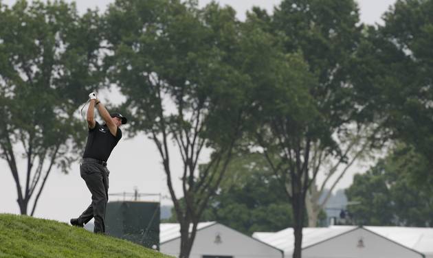 Phil Mickelson hits from rough on the 10th hole during the rain delayed first round of the U.S. Open golf championship at Oakmont Country Club on Friday