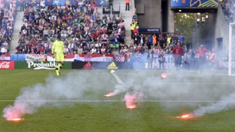 Flares are lobed onto the pitch during the Euro 2016 group D football match between Czech Republic and Croatia at the Geoffroy Guichard stadium in Saint Etienne