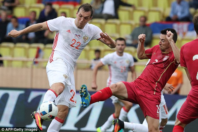 Russia's Artem Dzyuba hits a shot while under pressure from Serbia's Antonio Rukavina on Sunday