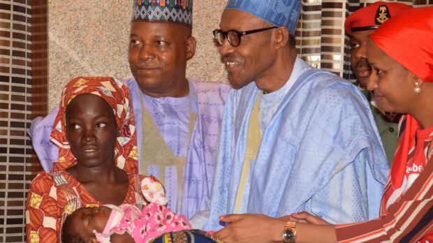 Nigeria President Muhammadu Buhari third right greets Amina Ali left the rescued Chibok school girl and her