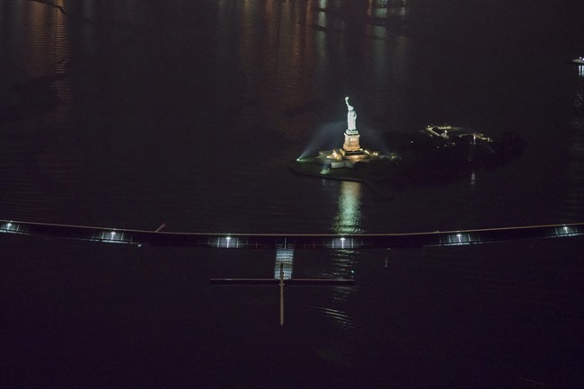 Revillard SI2 solar-powered airplane Solar Impulse 2 piloted by Swiss adventurer Andre Borschberg flies over the Statue of Libery in New York Saturday