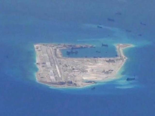 Chinese dredging vessels are purportedly seen in the waters around Fiery Cross Reef in the disputed Spratly Islands in the South China Sea in this still image from video taken by a P-8A Poseidon surveillance aircraft provided by the United States Navy May