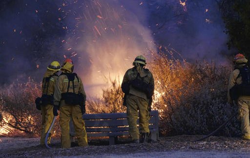 A fast-moving brush fire sweeping through hills northwest of downtown Los Angeles has damaged homes and prompted neighborhood evacuations. Los Angeles Coun